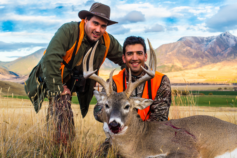 Two hunters with large deer
